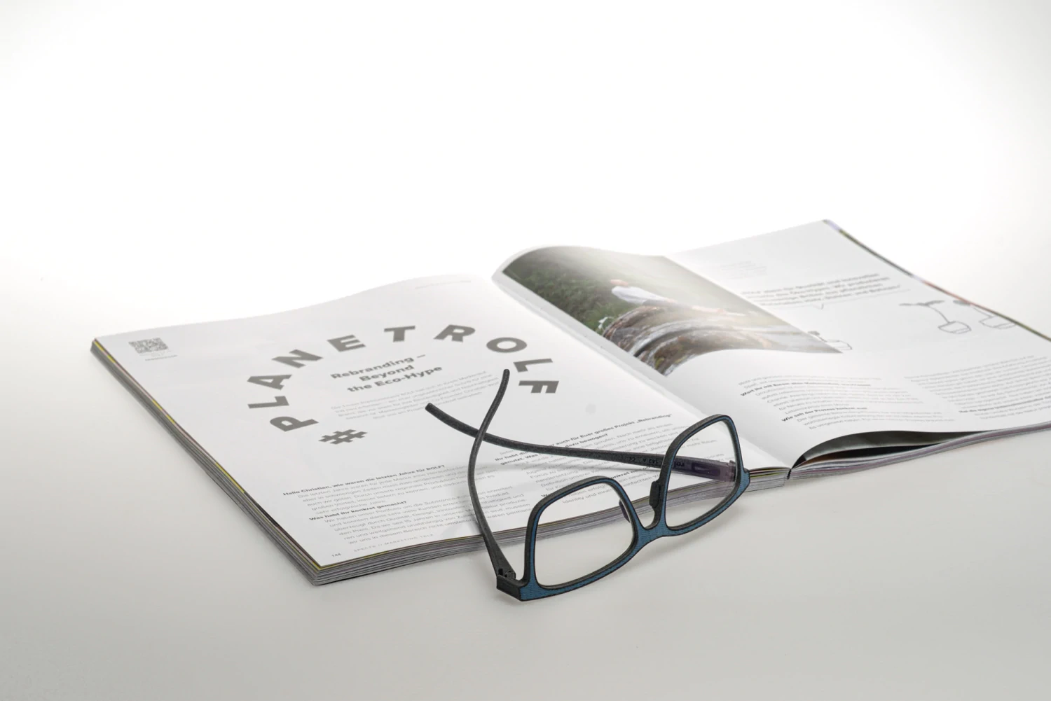 Lunettes Rolf rectangulaires bleu nuit posées sur un magazine ouvert